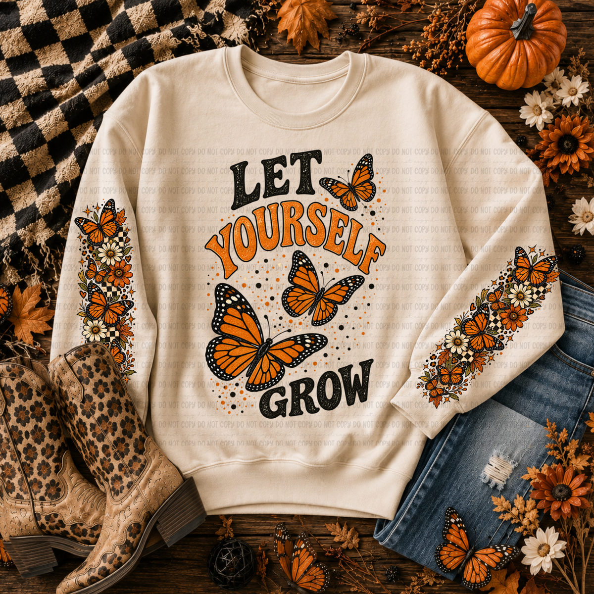 Cream sweatshirt with Let Yourself Grow lettering, orange butterflies, and floral details