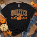 Sweater Weather fall t-shirt with camo varsity lettering and checker pumpkin graphic on black tee