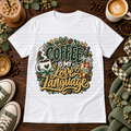 White graphic T-shirt with hot and iced coffee, bows, coffee beans, and the phrase Coffee Is My Love Language