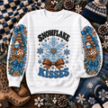 White sweatshirt with Snowflake Kisses lettering, blue snowflakes, mugs, evergreen trees, and bows